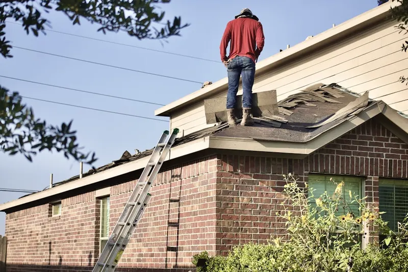 Professional roofer working on a residential roof in Calera